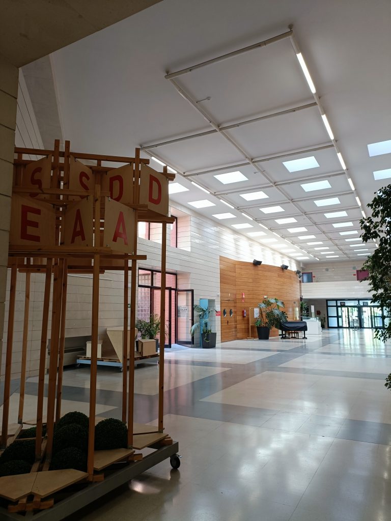 Przestronne jasne wnętrze, na pierwszym planie instalacja drewniana z napisem RESAD.