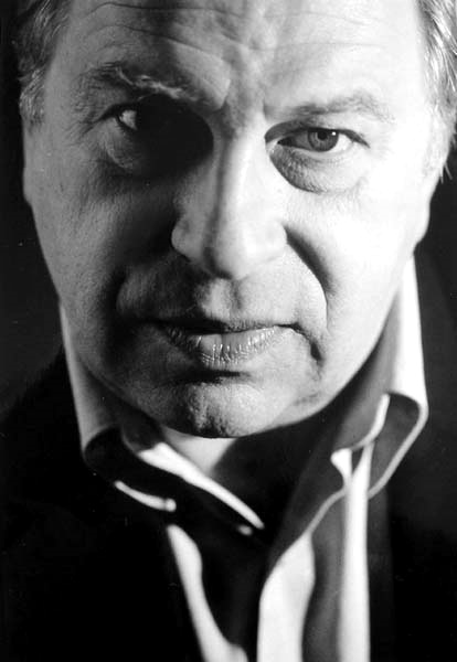 Czarno-biały portret mężczyzny w średnim wieku z poważnym wyrazem twarzy.