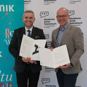 Dyrektor MIK-u Tomasz Włodarski i rektor AST dr hab. Grzegorz Mielczarek pozują na tle banerów obu instytucji. Z uśmiechem prezentują podpisane porozumienia.